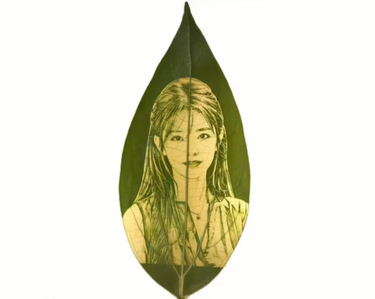 Artistic depiction of a woman's face on a green leaf