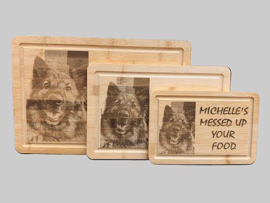 Three wooden trays with engraved picture and text designs and one with text on a grey background