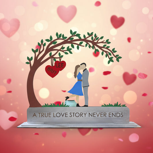 Decorative wall art with a couple under a tree and text 'A True Love Story Never Ends' on a white wall.