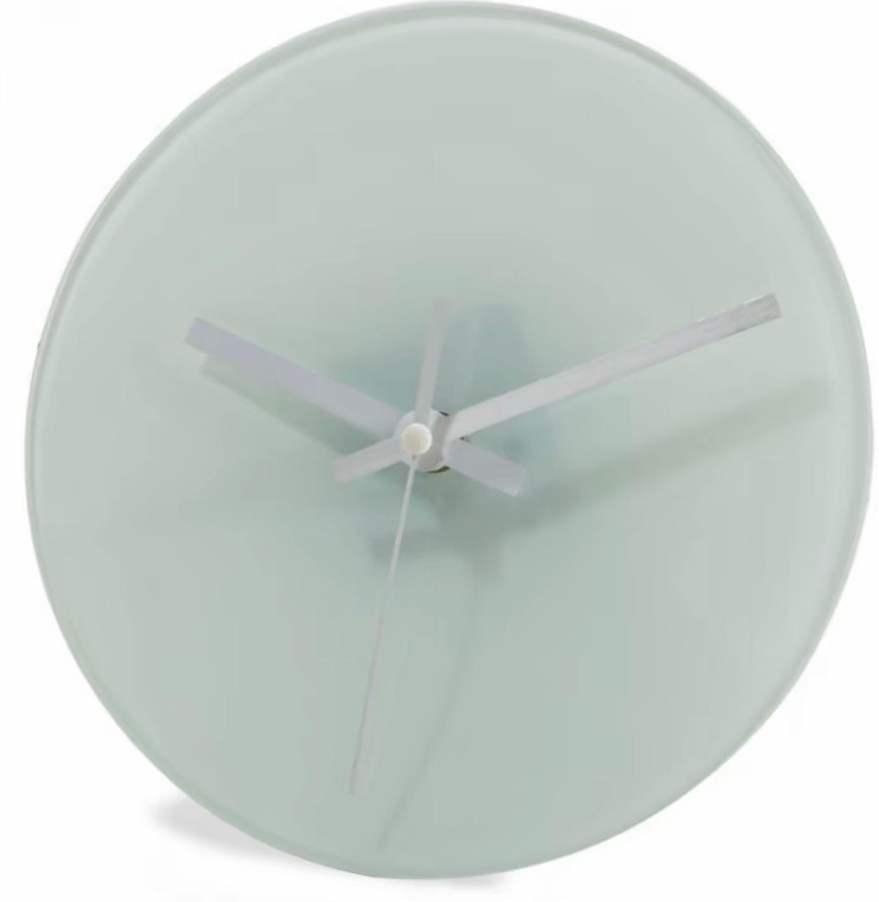 Round wall clock with a light green face and white hands on a white background