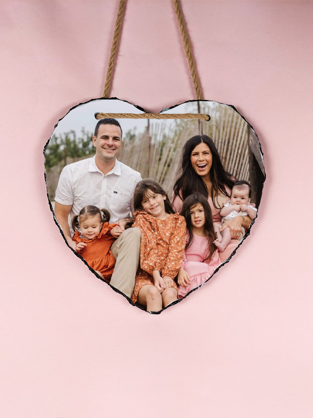 Heart-shaped photo plaque with a family picture on a pink background